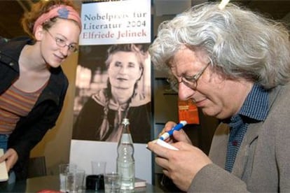 Peter Esterhazy, que recibirá mañana el Premio de la Paz de los libreros alemanes, firma ejemplares ayer junto a un cartel en el que aparece la Nobel Elfriede Jelinek.