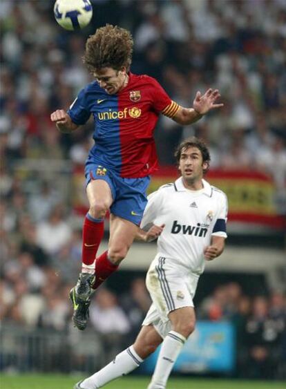 Puyol despeja un balón ante Raúl.