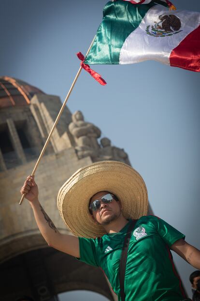 Un aficionado de la selección mexicana ondea la bandera nacional después del empate contra Polonia.