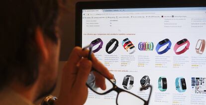 Un hombre consulta ofertas de relojes y pulseras medidoras de actividad física en una página web de internet.