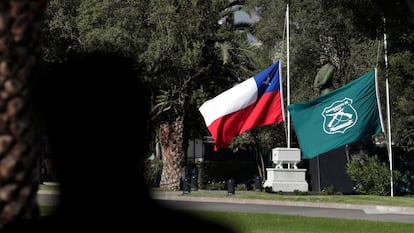 Las banderas de Chile y de la institución de Carabineros a media asta en la Escuela de Carabineros, este sábado en Santiago (Chile).