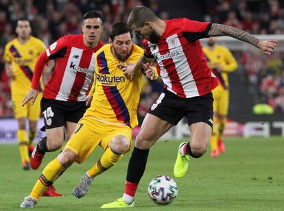 El defensa del Athletic Íñigo Martínez, a la derecha de la fotografía, disputa un balón con Messi.