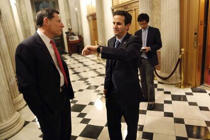 El senador estadounidense John Barrasso (i) y el senador Brian Schatz (d) charlan durante un descanso.
