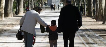 Unos abuelos acompañan a su nieto en el parque de El Retiro de Madrid.