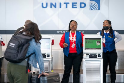 United Airlines employees help passengers check in at Ronald Reagan Washington National Airport in Arlington, Virginia, USA, 21 December 2023
