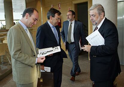 El diputado tránsfuga Eduardo Tamayo pasa tras el grupo en el que conversa el popular Antonio Beteta.