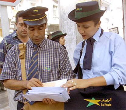 Una de las primeras mujeres cartero de Marruecos, junto a un colega hombre.