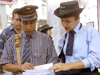 Una de las primeras mujeres cartero de Marruecos, junto a un colega hombre.