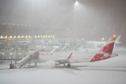 Un avión de Iberia aparcado en Barajas bajo la tormenta.