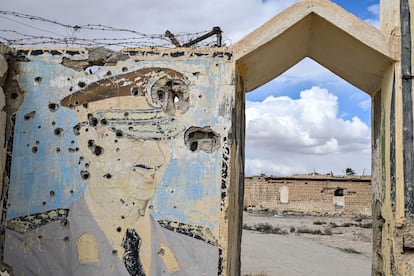 Un grafiti de Bachar el Asad en un muro acribillado en la entrada de una vieja zona militar de su régimen, en Palmira, al este de Siria.