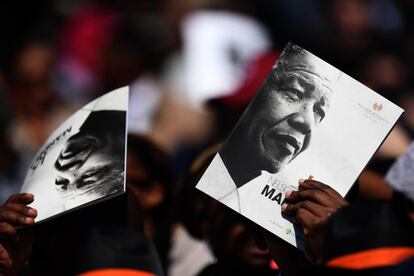 Varios asistentes se protegen del sol con el programa de la conferencia 'Nelson Mandela' que rinde tributo a la figura del fallecido presidente sudafricano, en Johannesburgo (Sudáfrica).