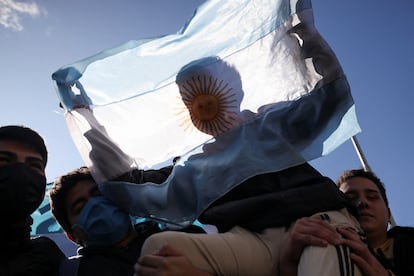 Un joven sostiene una bandera argentina mientras trabajadores desempleados e informales marchan en protesta contra las políticas económicas del gobierno, en Buenos Aires (Argentina), el jueves.