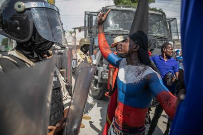 Ante la solicitud de ayuda de Henry a Naciones Unidas, algunos manifestantes han hecho un llamado al Gobierno ruso para que sean ellos quienes intervengan en la isla. En la imagen, un manifestante con los colores de la bandera rusa pintados sobre su cuerpo, discute con elementos de la policía antidisturbios de Haití. 