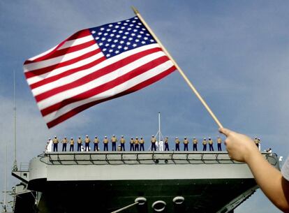 Ondean una bandera de Estados Unidos en el momento en que el portaviones Theodore Roosevelt, en la base naval de Norfolk, parte hacia el mar Mediterráneo, el 19 de septiembre del 2001. Estados Unidos organizó la operación "Justicia Infinita" en respuesta al ataque terrorista del día 11 de septiembre.