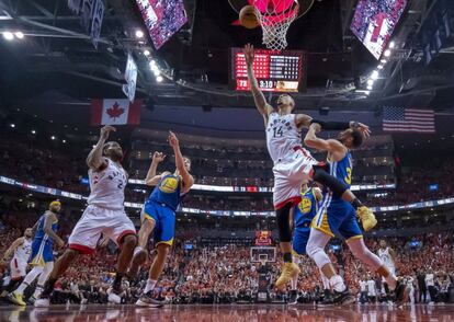 Danny Green de Toronto Raptors trata de rebotear ante la oposición del jugador de Golden State Warriors Stephen Curry.