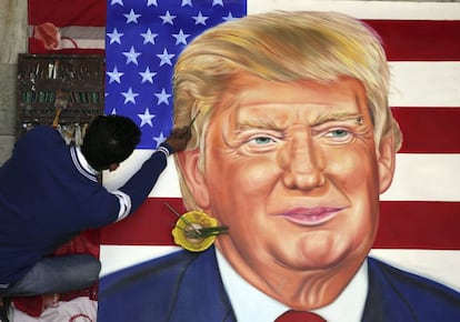 El artista indio Jagjot Singh Rubal retoca el retrato del presidente electo de EE.UU., Donald Trump, en la víspera de su ceremonia de toma de posesión, en Amritsar (India).