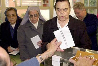 Una monja emite su voto, mientras otras dos hermanas esperan su turno en un colegio de Barcelona.