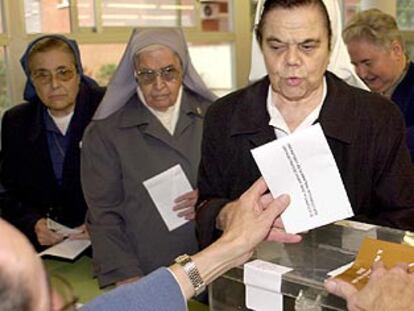 Una monja emite su voto, mientras otras dos hermanas esperan su turno en un colegio de Barcelona.