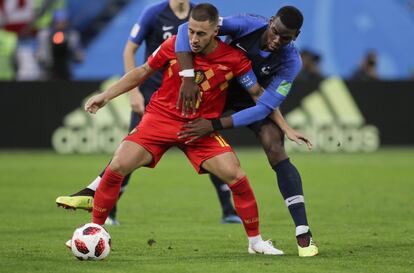 El belga Eden Hazard se lleva el balón ante el abrazo del jugador de Francia Paul Pogba.