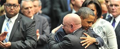 Barack Obama se abraza al marido de Gabrielle Giffords, Mark Kelly, en presencia de Daniel Hernandez (izquierda) y Michelle Obama (detrás).