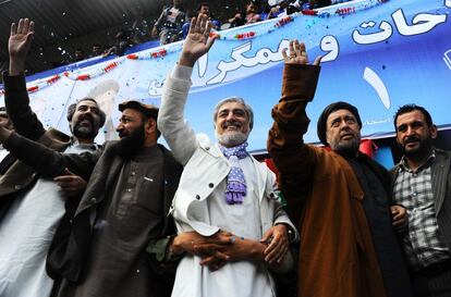 El candidato presidencial afgano Abdullah Abdullah (centro) y los candidatos a la vicepresidencia Mohammed Mohaqiq (2º derecha) y Mohammad Khan (2º izquierda) saludan a sus partidarios durante un acto de campaña en un estadio en la ciudad noroccidental de Herat el 1 de abril de 2014.
