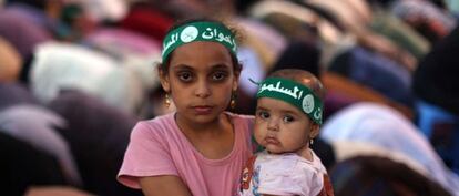 Una niña egipcia sujeta a un bebé durante el rezo de un grupo de seguidores de los Hermanos Musulmanes a las puertas de la mezquita Rabaa al Adawiya en El Cairo.