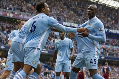 Balotelli, sujetado por Lescott, se dirige a los aficionados tras marcar.