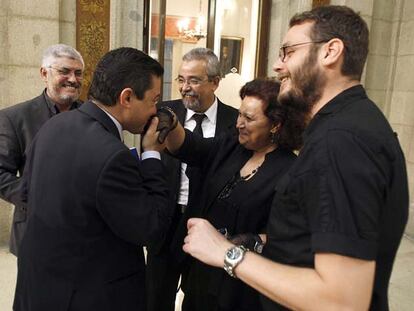 El concejal Pedro Calvo (PP) besa la mano de Milagros Hernández (IU) vestida de luto para el pleno.