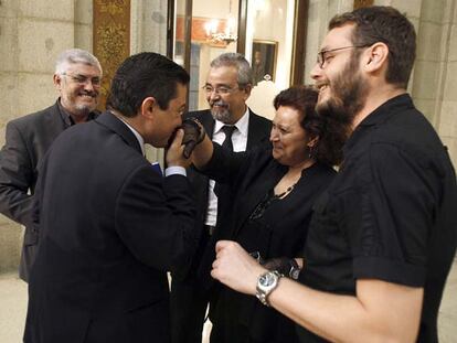 El concejal Pedro Calvo (PP) besa la mano de Milagros Hernández (IU) vestida de luto para el pleno.