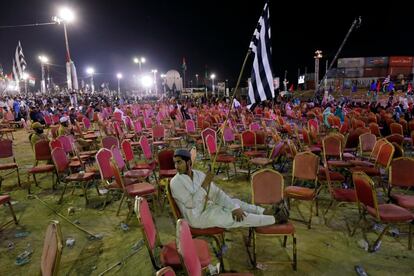 Un partidario del Movimiento Democrático de Pakistán (PDM), una alianza de partidos políticos de oposición, sujeta una bandera sentado en una silla, al término de una manifestación de protesta contra el gobierno en Karachi.