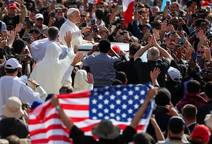 Un fiel muestra la bandera de EE UU al paso del Papa.