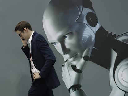 Un visitante al Mobile World Congress de Barcelona hablaba por teléfono mientras pasaba por un estand de inteligencia artificial, en febrero de 2018.