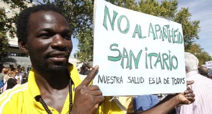 <span style="font-size: 8pt;">Un inmigrante se manifiesta en 2012 por la retirada del carné sanitario. / ULY MARTÍN (EL PAÍS)</span>