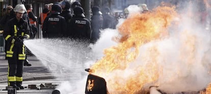Un bombero intenta extinguir las llamas de una barricada durante una protesta ante la nueva sede del Banco Central Europeo (BCE) en Fráncfort