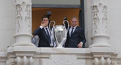 Cristiano Ronaldo (i) y Pepe saludan desde el Ayuntamiento de Madrid.