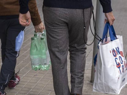 Dos personas vuelven de la compra en Barcelona.