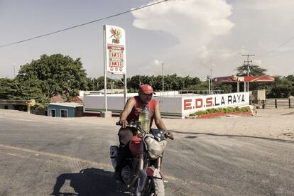 Junto con los alimentos, que se llevan la mayor tajada del gasto de los colombianos, la subida anunciada del precio de los combustibles se prevé que generarán el mayor impacto en el bolsillo de la población colombiana. En la imagen, un motociclista carga una botella llena de gasolina cerca de la frontera colombo-venezolana en Paraguachón.