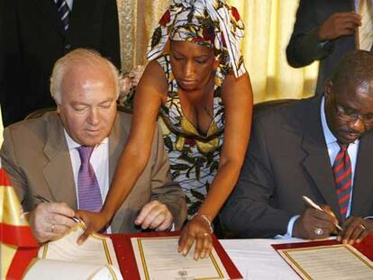 El ministro español de Asuntos Exteriores, Miguel Angel (izquierda), y su homólogo de Guinea-Conakry, Mamadi Conde (derecha), firman un acuerdo de cooperación en materia de inmigración.