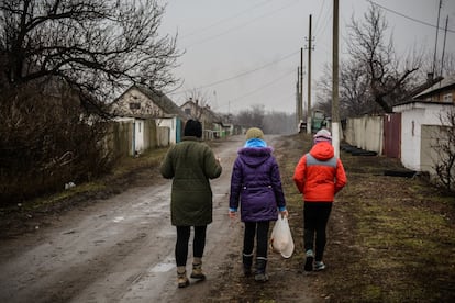 <p>Unos 50.000 niños continúan viviendo en la línea del frente. Se encuentran en una situación de desprotección y vulnerabilidad que ha empeorado con la crisis de la covid-19. Cerca del puesto de control fronterizo de Mayorsk, uno de los cinco del este de Ucrania, se reúnen cada sábado los niños de Zaitseve. Esta pequeña población de 3.000 habitantes antes de la guerra quedó dividida en cuatro por el conflicto. La escuela, la iglesia y un amplio territorio quedaron en la República Popular de Donetsk (DNR, por sus siglas en ruso). Tres fragmentos más, alejados entre sí, terminaron bajo control del Gobierno ucraniano.</p> <p>Unicef estima que más de 100.000 niños viven a una distancia menor de diez kilómetros de la línea del frente. En la imagen, Helena Rozvadovska (35), exportavoz de la Oficina Presidencial de Defensa de la Infancia y actualmente voluntaria en la asociación Voices of Children, acompaña a dos niñas a casa para solicitar el permiso a los padres y llevarles una semana de excursión a Leópolis, en la otra punta del país, con el resto de sus compañeros. </p>