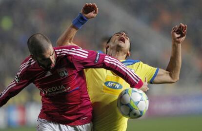 Lisandro, delantero del Olympique de Lyon, pelea el cuero con Poursaitides.