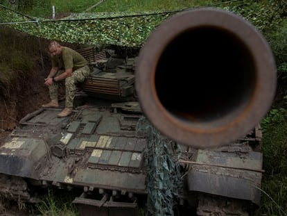 A Ukrainian serviceman rests on a tank on the front lines in the Donetsk region.