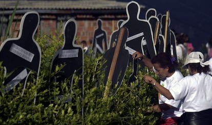 Familiares de desaparecidos, ante siluetas con sus nombres, el pasado sábado en Medellín.