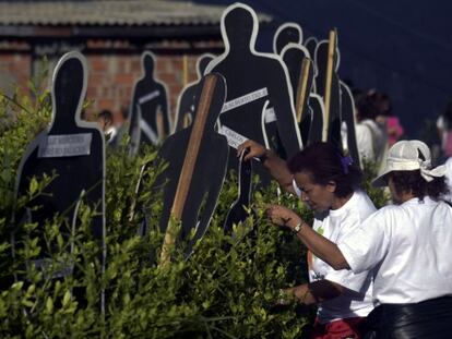Familiares de desaparecidos em frente às silhuetas com seus nomes.
