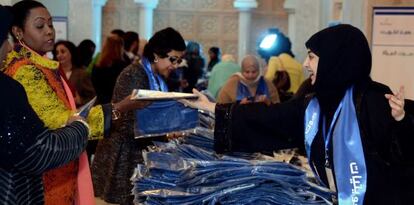 Una voluntaria reparte camisetas electorales en Kuwait City