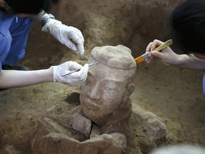 Arqueólogos chinos trabajan en la limpieza de uno de los nuevos guerreros de terracota recién descubiertos en Xian (China).