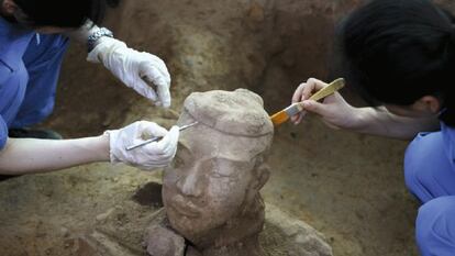 Arqueólogos chinos trabajan en la limpieza de uno de los nuevos guerreros de terracota recién descubiertos en Xian (China).