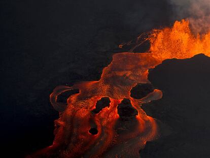 FILE - In this June 10, 2018 photo, lava from the Kilauea volcano continues to erupt from a fissure and forms a river of lava flowing down to Kapoho in Pahoa, Hawaii. (AP Photo/L.E. Baskow, File)