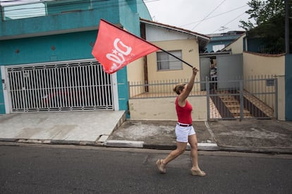 Uma mulher carrega a bandeira da campanha de Dilma durante a jornada eleitoral, em São Bernardo do Campo.