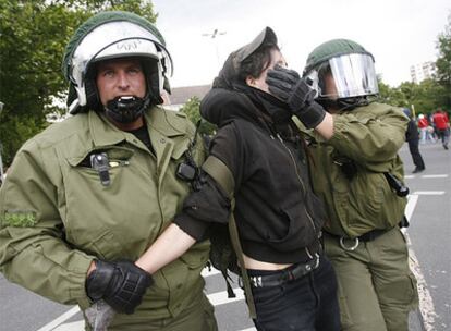 Dos policías detienen a un participante en las protestas contra el uso de los terrenos del antiguo aeropuerto de Berlín