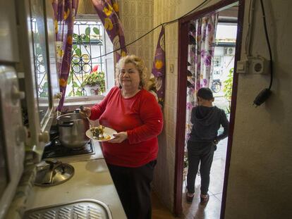 Carmen García en la cocina de su casa, en el Puerto de Santa María. Al lado, uno de sus nietos.